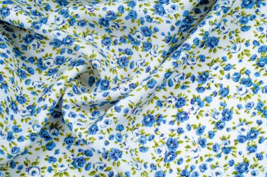 Arka plan doku, desen. küçük mavi çiçekler ile ince pamuklu kumaş. Kumaş zeytin yeşil çiçek sapları ve küçük mavi - aqua çiçek karışımı olan beyaz bir arka plana sahiptir. 