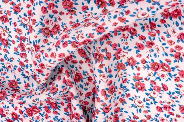 Arka plan doku, küçük kırmızı çiçekli ince pamuklu kumaş. Orta ağırlıkta, kapitone bez veya kumaş pamuk kumaş küçük yaz çiçek, pembe, mor, sarı, yeşil yapraklar, beyaz arka plan üzerinde