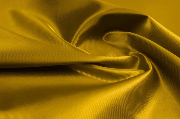 Texture, background, pattern. A yellow satin is a silk fabric