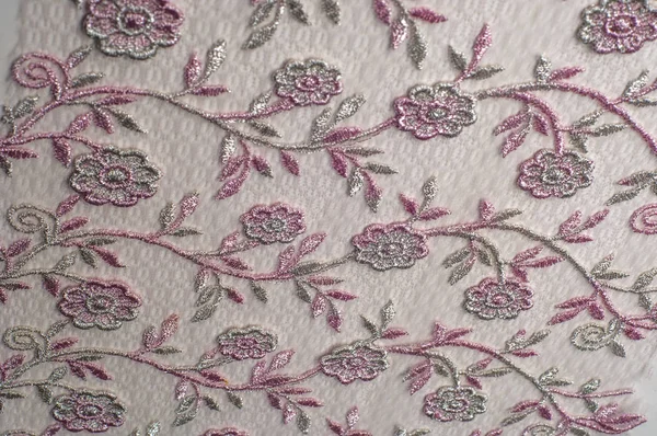 Doku, arka plan, desen. Pembe dantel çiçek üzerinde beyaz bir arka plan ile dekore edilmiştir. Arka planını çiçekler ile dekore edilmiş pembe dantel kumaş