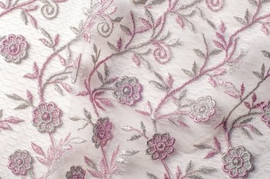 Doku, arka plan, desen. Pembe dantel çiçek üzerinde beyaz bir arka plan ile dekore edilmiştir. Arka planını çiçekler ile dekore edilmiş pembe dantel kumaş