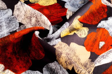 Doku, arka plan, desen. Bir kadının ipek mendil parlak renklerle dekore edilmiştir. Siyah bir zemin üzerine beyaz sarı kırmızı çiçekler