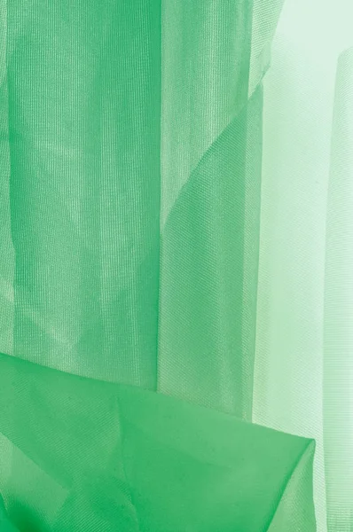 Texture, background, pattern. The texture of the silk fabric is green. Silk fabric is transparent. Fabric or liquid wave illustration of wavy creases of silk satin texture or velvet material