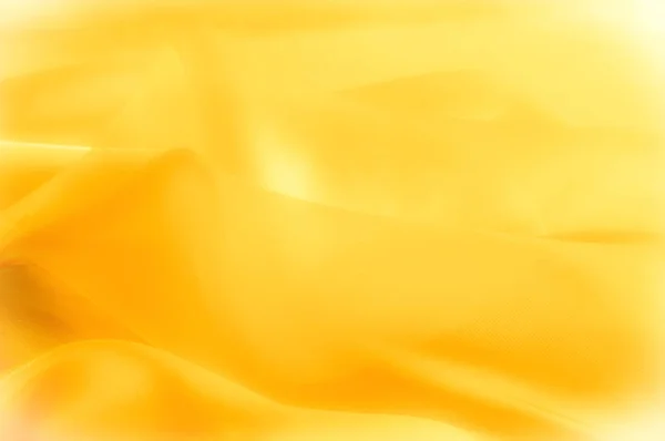 写真がぼやけています テクスチャ パターン 黄色のシルクの生地 豪華な黄色の背景を抽象的なファブリックや液体波または波状のグランジ テクスチャ 全体背景 — ストック写真