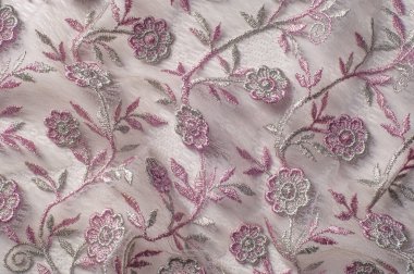 Doku, arka plan, desen. Pembe dantel çiçek üzerinde beyaz bir arka plan ile dekore edilmiştir. Arka planını çiçekler ile dekore edilmiş pembe dantel kumaş