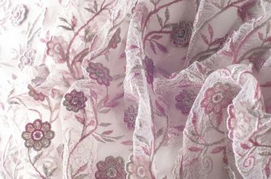 Doku, arka plan, desen. Pembe dantel çiçek üzerinde beyaz bir arka plan ile dekore edilmiştir. Arka planını çiçekler ile dekore edilmiş pembe dantel kumaş