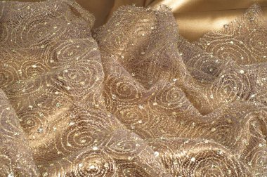 Doku, arka plan, desen. Dantel kumaş bej parıldıyor ile altın. Muhteşem ışıltılı çiçek dantel antik şekerleme renkli Edwardian dönemi ruhu içinde altın metalik iplik ile. 