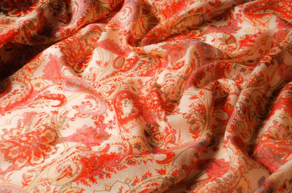 Texture, pattern, background. Silk fabric - paisley on a beige b
