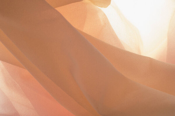 Texture, background, pattern. Silk transparent fabric. Blue yellow pink shades. of a color intermediate between red and white, as of coral or salmon.