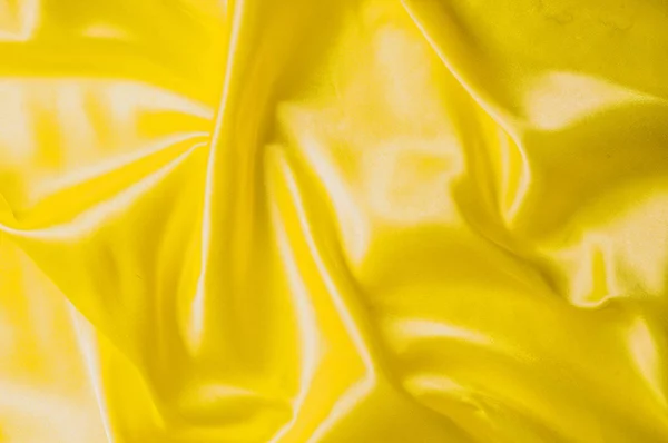De patroon van de achtergrond van de textuur. Zijde stof, gele stof. Op een bla — Stockfoto