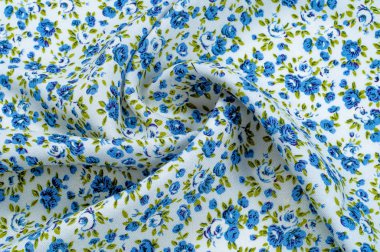 Arka plan doku, desen. küçük mavi çiçekler ile ince pamuklu kumaş. Kumaş zeytin yeşil çiçek sapları ve küçük mavi - aqua çiçek karışımı olan beyaz bir arka plana sahiptir. 