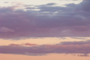 Doku, arka plan, desen. Gökyüzü günbatımı, şafakta değildir. Renkli bulutlar, kırmızı, koyu mavi, turuncu, pastel renkler. Alacakaranlık romantik pastel gökyüzü. Dinamik dramatik ifade bulutlu gökyüzü