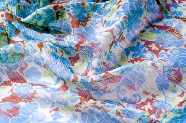 Doku, arka plan, desen. Kumaş krep de chine. Mavi beyaz pişmiş toprak yeşil. Kumaş üzerine boyalı çiçekler vardır. Soyut çizim