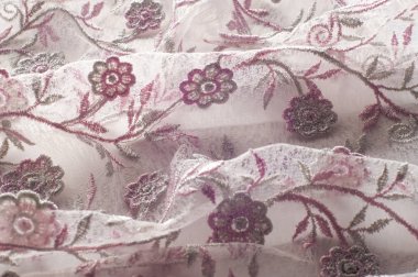 Doku, arka plan, desen. Pembe dantel çiçek üzerinde beyaz bir arka plan ile dekore edilmiştir. Arka planını çiçekler ile dekore edilmiş pembe dantel kumaş