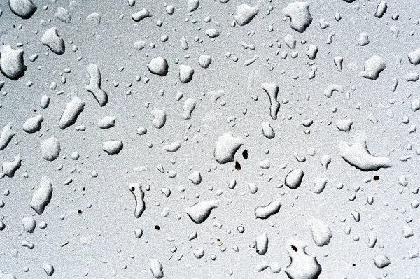 Lluvia de verano, gotas de agua en la pintura del coche. una pequeña ronda o p — Foto de Stock