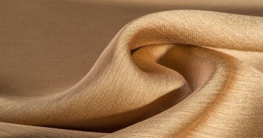 Arka plan, desen, doku, bej altın ipek kumaş Pürüzsüz mat bir kaplamaya sahiptir ve hafif bükümlü bir iplik sayesinde dayanıklıdır. Tasarımdan projelerinize kadar her şey için bu lüks kumaşı kullanın