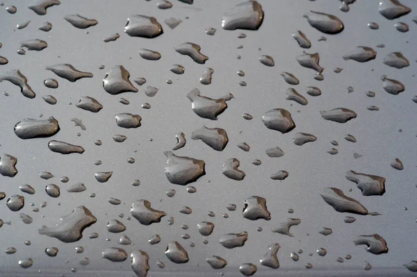 Pioggia estiva, gocce d'acqua sulla vernice dell'auto. un piccolo giro o p — Foto Stock