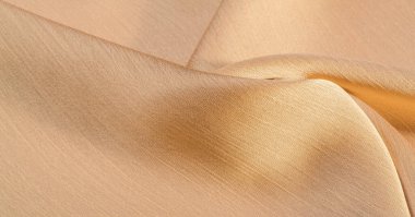 Arka plan, desen, doku, bej altın ipek kumaş Pürüzsüz mat bir kaplamaya sahiptir ve hafif bükümlü bir iplik sayesinde dayanıklıdır. Tasarımdan projelerinize kadar her şey için bu lüks kumaşı kullanın