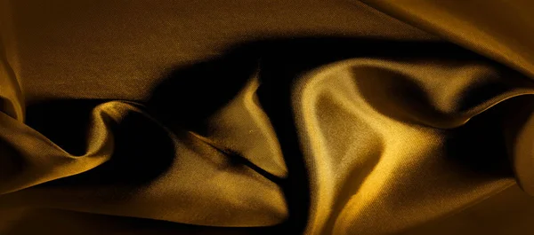 Текстура, фон, узор. золотисто-жёлтая шелковая ткань — стоковое фото