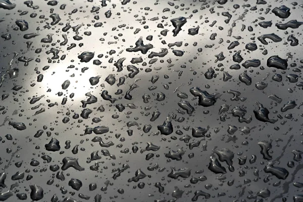Lluvia de verano, gotas de agua en la pintura del coche. una pequeña ronda o p — Foto de Stock
