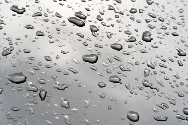 Lluvia de verano, gotas de agua en la pintura del coche. una pequeña ronda o p — Foto de Stock