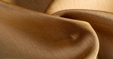 Arka plan, desen, doku, bej altın ipek kumaş Pürüzsüz mat bir kaplamaya sahiptir ve hafif bükümlü bir iplik sayesinde dayanıklıdır. Tasarımdan projelerinize kadar her şey için bu lüks kumaşı kullanın