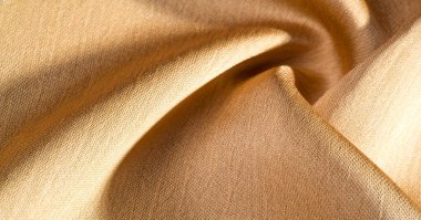 Arka plan, desen, doku, bej altın ipek kumaş Pürüzsüz mat bir kaplamaya sahiptir ve hafif bükümlü bir iplik sayesinde dayanıklıdır. Tasarımdan projelerinize kadar her şey için bu lüks kumaşı kullanın