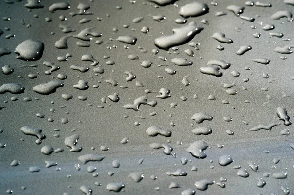 Lluvia de verano, gotas de agua en la pintura del coche. una pequeña ronda o p —  Fotos de Stock