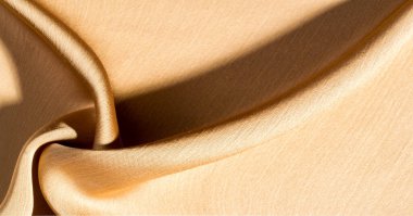 Arka plan, desen, doku, bej altın ipek kumaş Pürüzsüz mat bir kaplamaya sahiptir ve hafif bükümlü bir iplik sayesinde dayanıklıdır. Tasarımdan projelerinize kadar her şey için bu lüks kumaşı kullanın