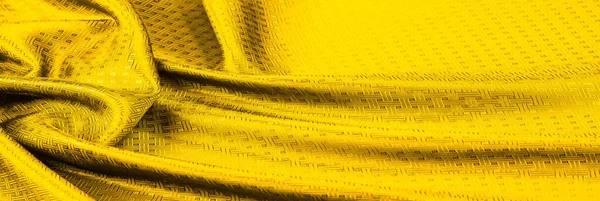 Background texture, pattern. Yellow, mustard silk fabric with a