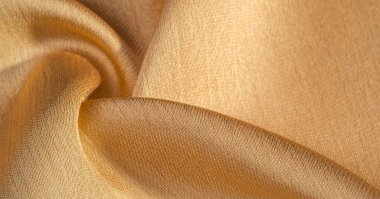 Arka plan, desen, doku, bej altın ipek kumaş Pürüzsüz mat bir kaplamaya sahiptir ve hafif bükümlü bir iplik sayesinde dayanıklıdır. Tasarımdan projelerinize kadar her şey için bu lüks kumaşı kullanın