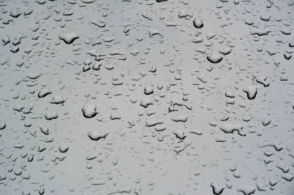 Pioggia estiva, gocce d'acqua sulla vernice dell'auto. un piccolo giro o p — Foto Stock
