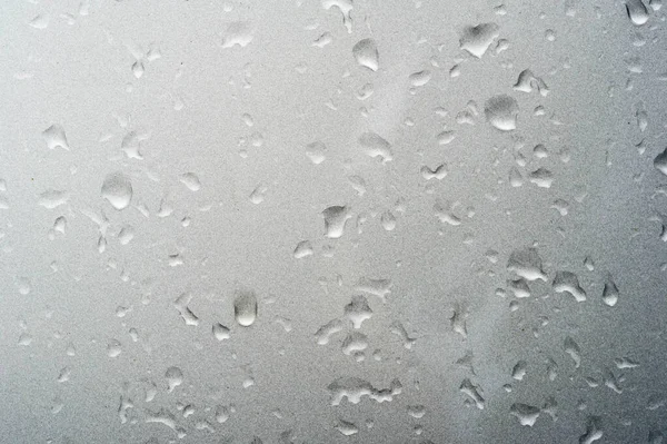 Lluvia de verano, gotas de agua en la pintura del coche. una pequeña ronda o p — Foto de Stock