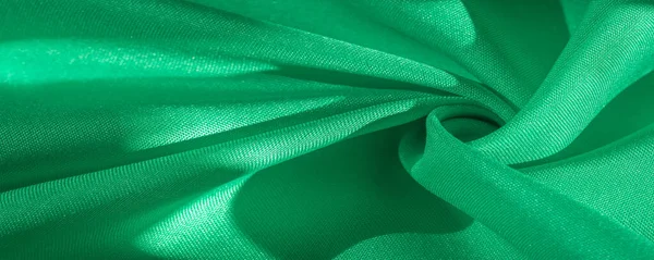 Texture, silk fabric of green color, solid light green silk sati