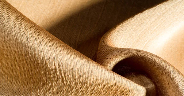 Arka plan, desen, doku, bej altın ipek kumaş Pürüzsüz mat bir kaplamaya sahiptir ve hafif bükümlü bir iplik sayesinde dayanıklıdır. Tasarımdan projelerinize kadar her şey için bu lüks kumaşı kullanın