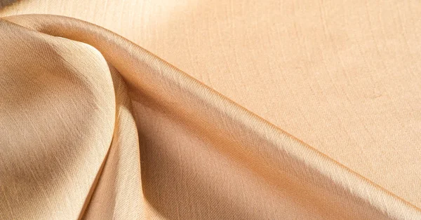 Background, pattern, texture, beige golden silk fabric It has a smooth matte finish and is durable due to a slightly twisted yarn. Use this luxurious fabric for anything - from design to your projects