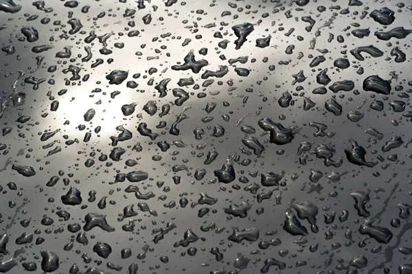 Lluvia de verano, gotas de agua en la pintura del coche. una pequeña ronda o p —  Fotos de Stock