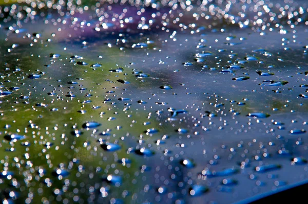 The photo is blurred, raindrops on the car paintwork — Stock Photo, Image