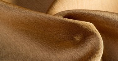 Arka plan, desen, doku, bej altın ipek kumaş Pürüzsüz mat bir kaplamaya sahiptir ve hafif bükümlü bir iplik sayesinde dayanıklıdır. Tasarımdan projelerinize kadar her şey için bu lüks kumaşı kullanın