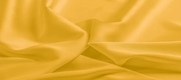 stock image background texture, pattern. Yellow silk fabric. A very light fa