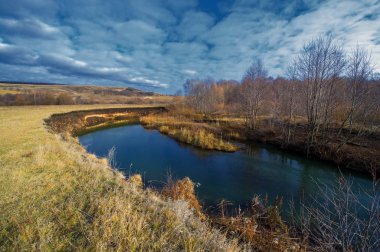 Kış, sonbahar manzarası. Buzlu nehir, yapraksız ağaçlar.