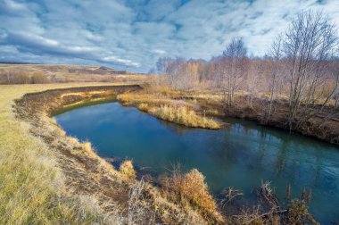 Kış, sonbahar manzarası. Buzlu nehir, yapraksız ağaçlar.