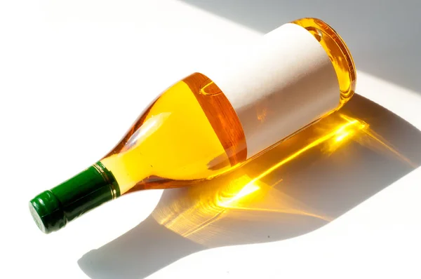 Bottle of light wine, white label, lies on white background. Pla — Stock Photo, Image