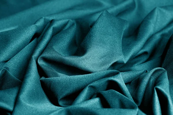 Textured, background, pattern, turquoise fabric. This is an unusual fabric that has an elegant appearance with a rich and coarse texture. It is tightly knit with designs built into the fabric itself