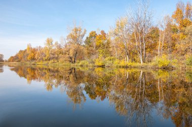 Sonbahar, sudaki ağaçların göldeki yansıması üzerine sessizdir.