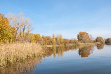 Sonbahar, sudaki ağaçların göldeki yansıması üzerine sessizdir.