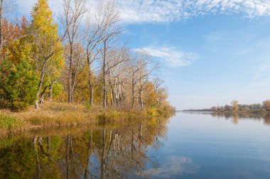 Sonbahar, sudaki ağaçların göldeki yansıması üzerine sessizdir.