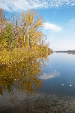 Sonbahar, sudaki ağaçların göldeki yansıması üzerine sessizdir.