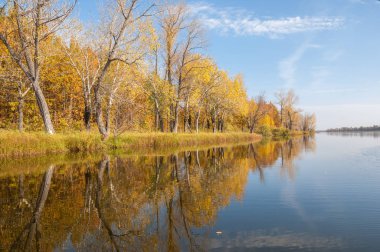 Sonbahar, sudaki ağaçların göldeki yansıması üzerine sessizdir.