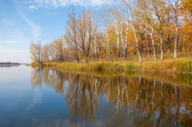 Sonbahar, sudaki ağaçların göldeki yansıması üzerine sessizdir.